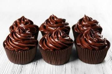 Chocolate cupcakes on light wooden background
