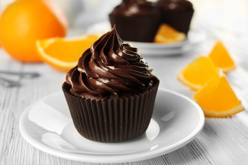 Cupcakes served with orange and drink on table