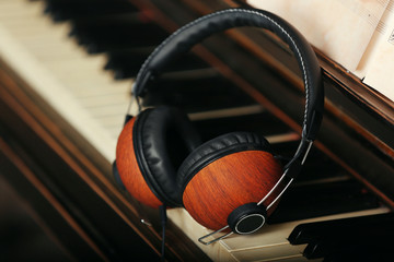 Brown headphones on piano keyboard, close up