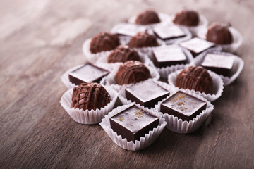 Assorted chocolate candies on wooden background