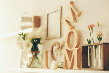 Wooden decor and flowers for mother's day on a shelf