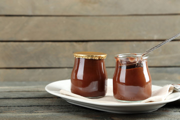 Chocolate dessert in a small glass jars on wooden background