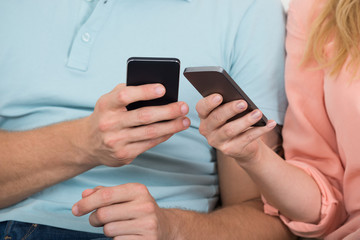 Couple Using Smart Phones To Share Files
