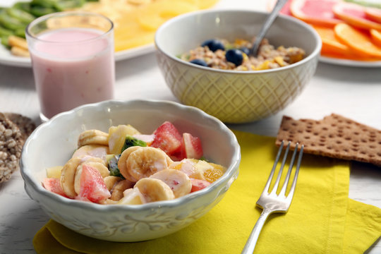 Tasty oatmeal and fruit salad on wooden background. Healthy eating concept.