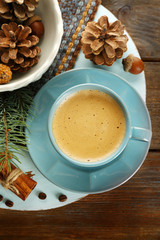 Cup of coffee and Christmas tree branch on wooden mat