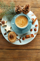 Cup of coffee with star shaped biscuits and Christmas tree branch on wooden mat