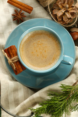 Cup of coffee on napkin on wooden tray, top view