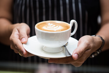 woman holding hot cup of coffee