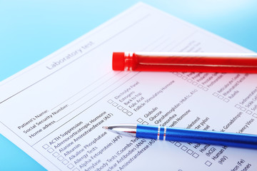Obraz premium Blood in test tubes, pen and investigation form on the table
