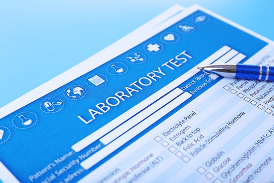 Laboratory test list with pen on blue background, close up