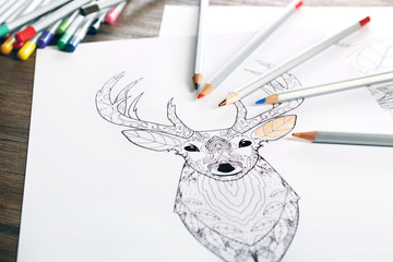 Coloring of deer with pencils on table
