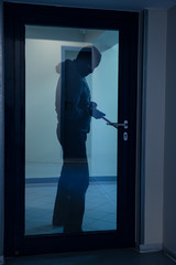 Burglar Using Crowbar To Open Glass Door