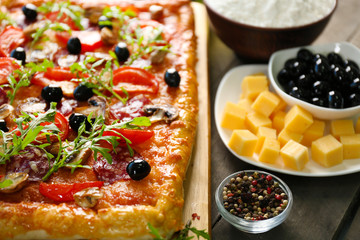 Rectangle delicious pizza and vegetables on the table, close-up