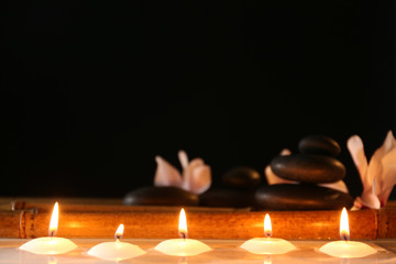 Obraz na płótnie Canvas Spa still life with candles in water on dark background