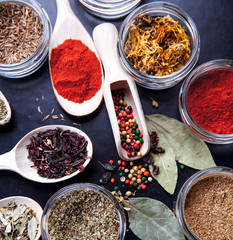 Fototapeta premium Spices on black background in special jars. Food