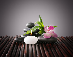 Spa still life with beautiful flower and candlelight on grey background