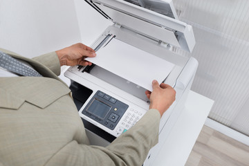 Businessman Keeping Paper On Photocopy Machine