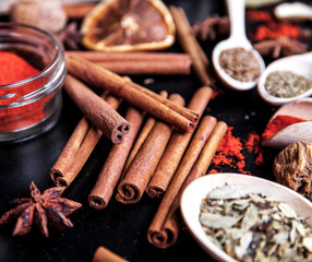 wooden spoons with spices on black background