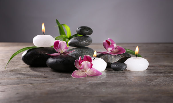 Fototapeta Spa still life with beautiful flower and candlelight on wooden table closeup