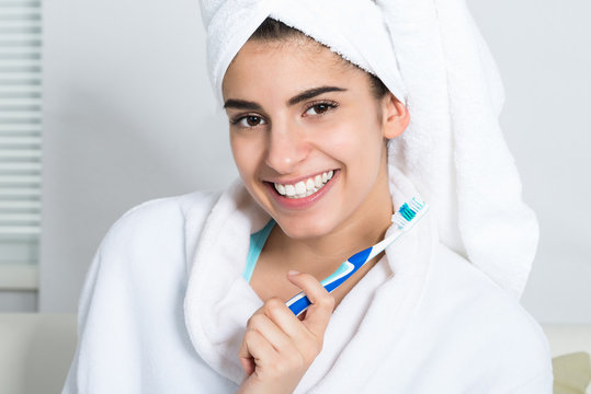 Happy Woman Holding Toothbrush In Bathroom