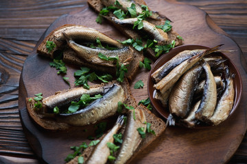 Smoked sprats in oil and sandwiches, studio shot