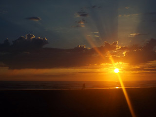 Cloudy Sunset Over the Ocean with Sunbeams in the Sky