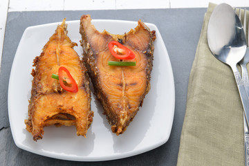 Fried fish on plate on white plate
