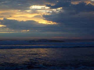 Cloudy Sunset Over the Ocean with Waves in the Foreground