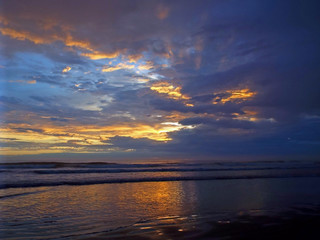 Cloudy Sunset Over the Ocean with Waves in the Foreground