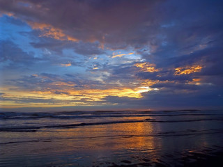 Cloudy Sunset Over the Ocean with Waves in the Foreground