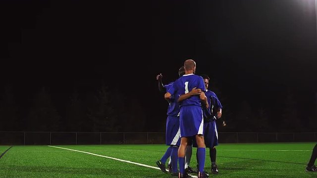 A soccer team celebrates after a game
