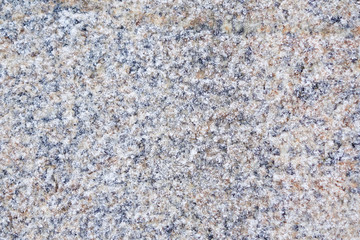 Winter background stone granite slab covered with frost. Closeup.