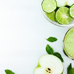 Vegetable juice, apple, sliced lime on the white wooden backgrou - 100782281