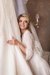 Beautiful bride looks at her wedding dress