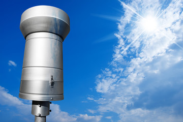 Metallic Rain Gauge on Blue Sky / Weather station with metallic rain gauge on a blue sky with clouds and sun rays