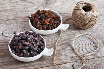 Dried raisins Turkish and Spanish (Malaga). Turkish raisins, Sultan raisins pitted . Raisins from Malaga with stones. Dried raisins on the wood backgraund