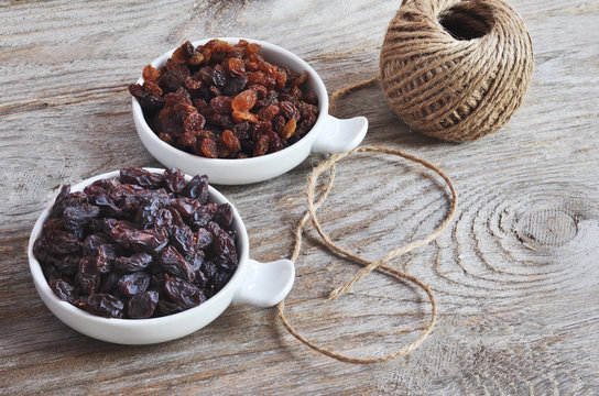 Dried Raisins Turkish And Spanish (Malaga). Turkish Raisins, Sultan Raisins Pitted . Raisins From Malaga With Stones. Dried Raisins On The Wood Backgraund