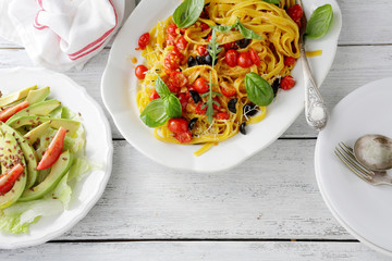 pasta and salad on wooden table