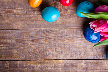 Easter egg and tulips on wooden background.