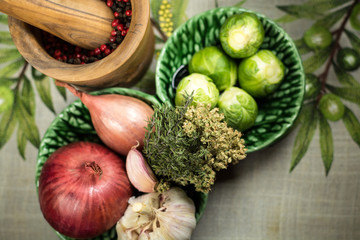 Spices, garlic, onion on table cloth woth green olives