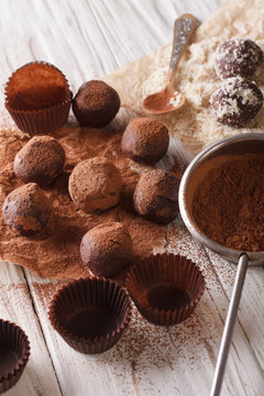 sprinkling chocolate truffles cocoa powder and nuts close-up. vertical
