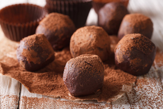 Chocolate truffles in cocoa macro on a wooden table. horizontal 