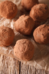 Chocolate truffles close-up on a wooden table. vertical
