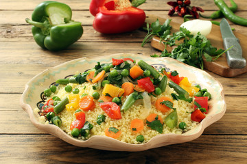 couscous con verdure  in piatto di ceramica sfondo rustico