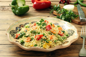 couscous con verdure  in piatto di ceramica sfondo rustico