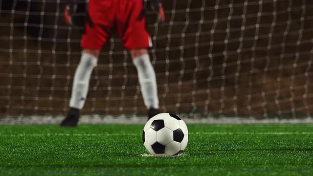 Close up of a soccer player making a penalty kick and shooting it too high