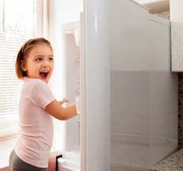 Happy child playing with   fridge