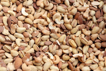 Cashews and pistachios background, all brown dried fruit