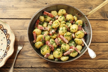 vista dall'alto patate cucinate con bacon in padella di metallo sfondo rustico