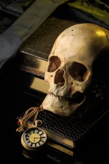 Fotobehang Oude meesters human skull on a book next to the clock. concept of black magic  © kopitinphoto